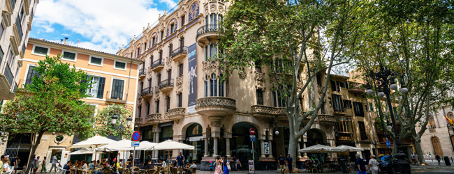 Schöne Cafes in der Altstadt von Palma de Mallorca Menschen sitzen und laufen über einen Platz in der Altstadt von Palma de Mallorca mit Cafes und Geschäften