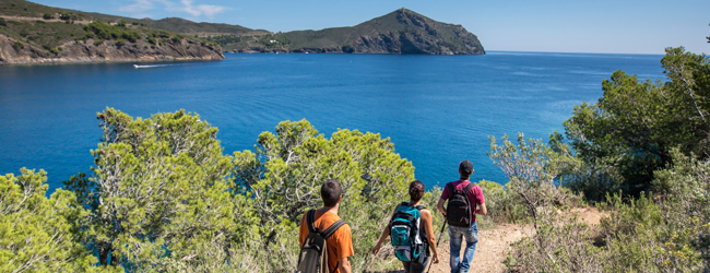 Schöne Wanderung entlang der Küst auf Mallorca Drei Personen wandern entlang der Küste mit Blick auf das Meer bei einer Sprachreise auf Mallorca