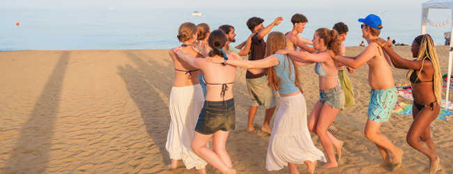 Viele Jugendliche tanzen und spielen am Strand im Sommer bei einer LISA! Schülersprachreise in Malaga